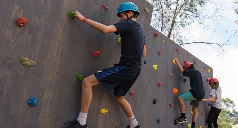 Kids tackle the new bouldering wall at Next Level Monkey Business